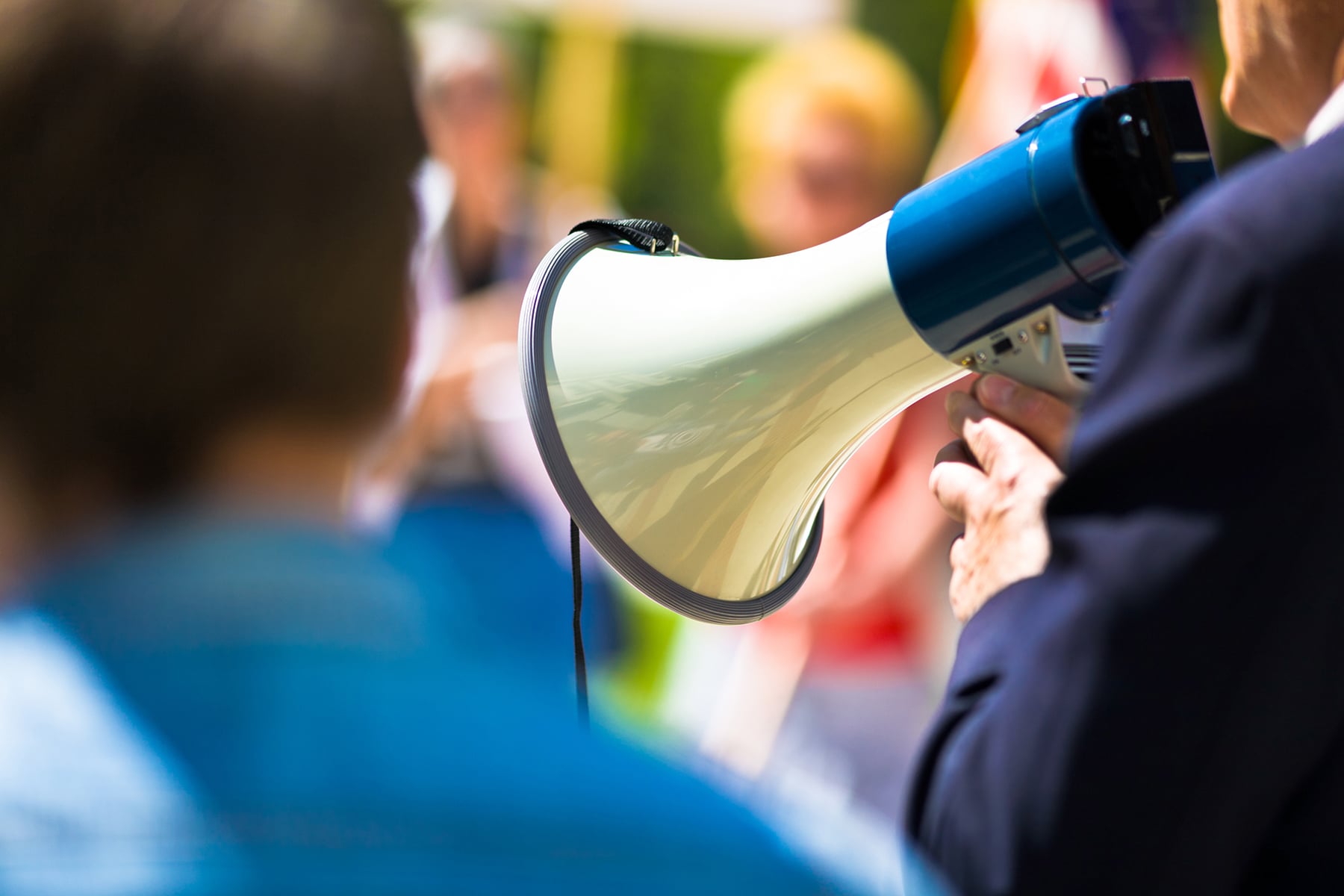 Person with megaphone speaking to a crowd.
