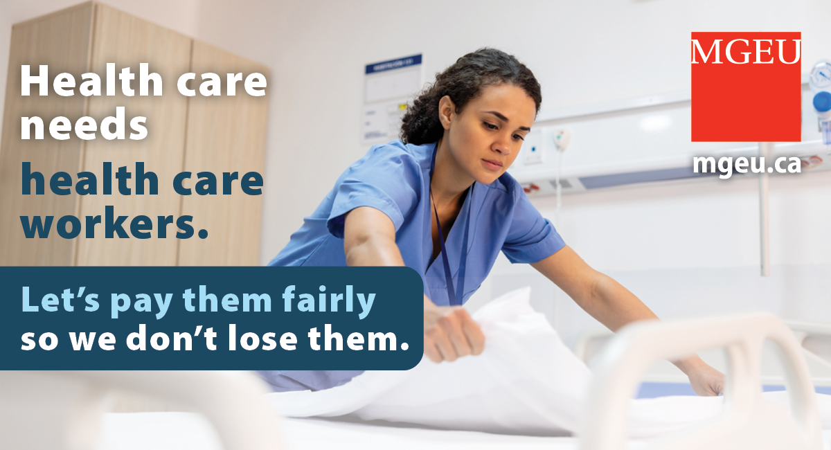 health care workers in blue scrubs making a hospital bed