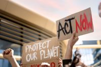 protestors with signs saying "Act Now" and "Protect our planet"