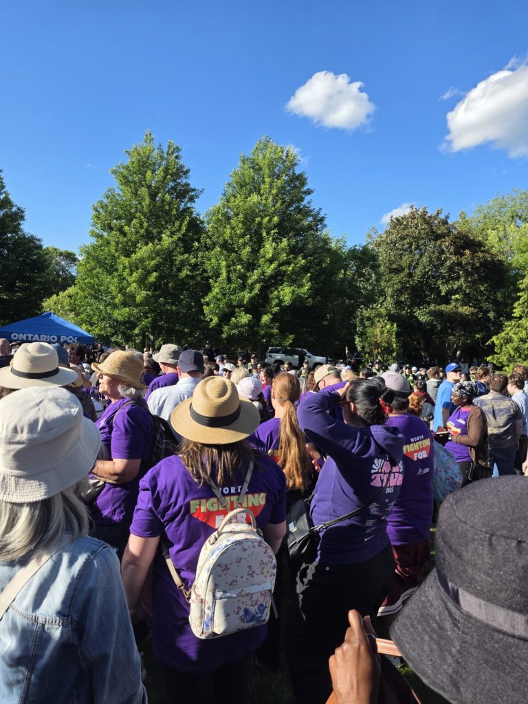 JP Hornick, OPSEU/SEFPO President with striking social services workers wearing purple tshirts that say Worth Fighting For on the front